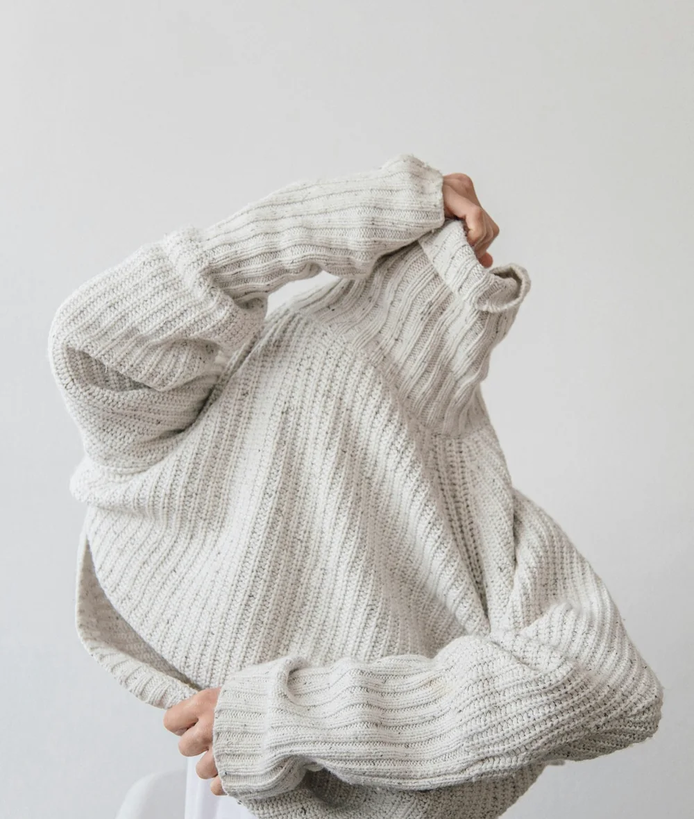 Textured cream knitwear styled in a clean studio setting
