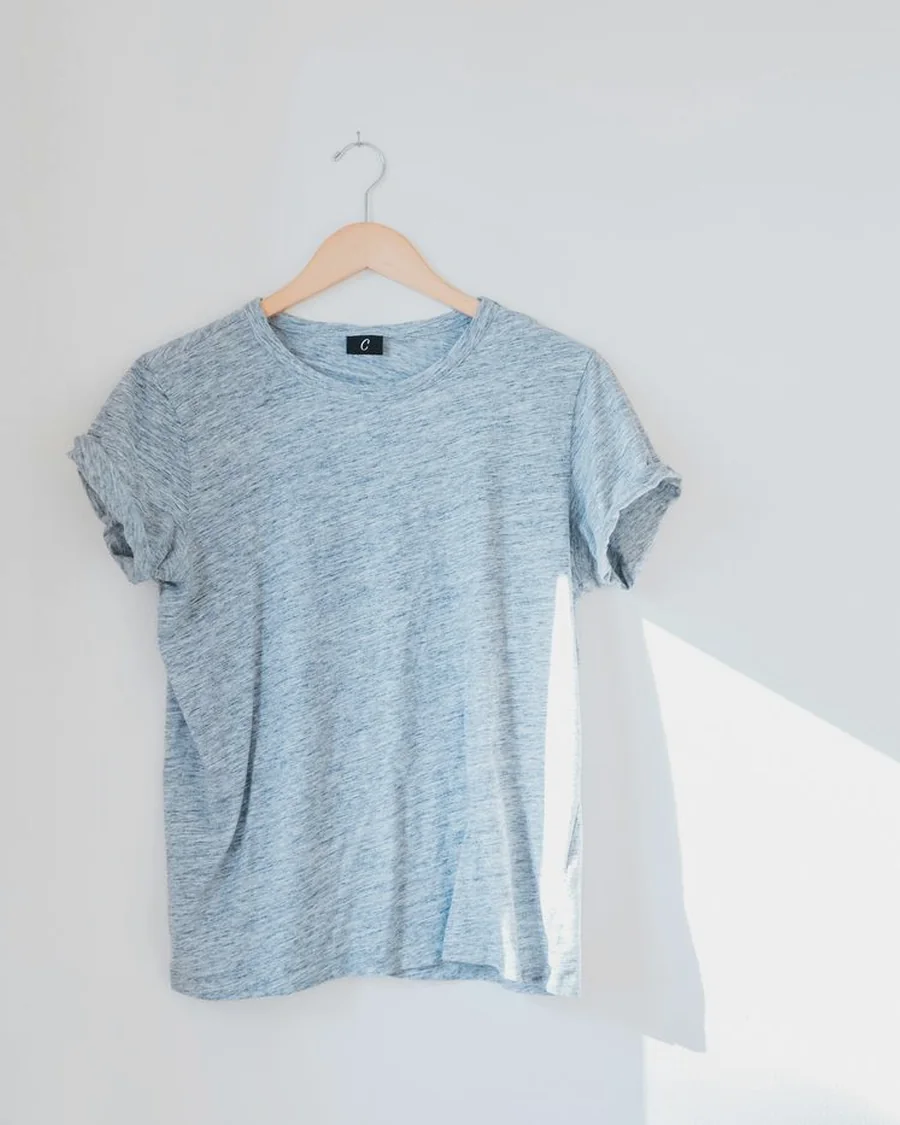 Minimal cotton t-shirt hanging in soft daylight